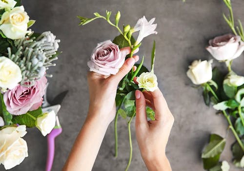 The skilled hands of a floral designer, carefully arranging a bouquet